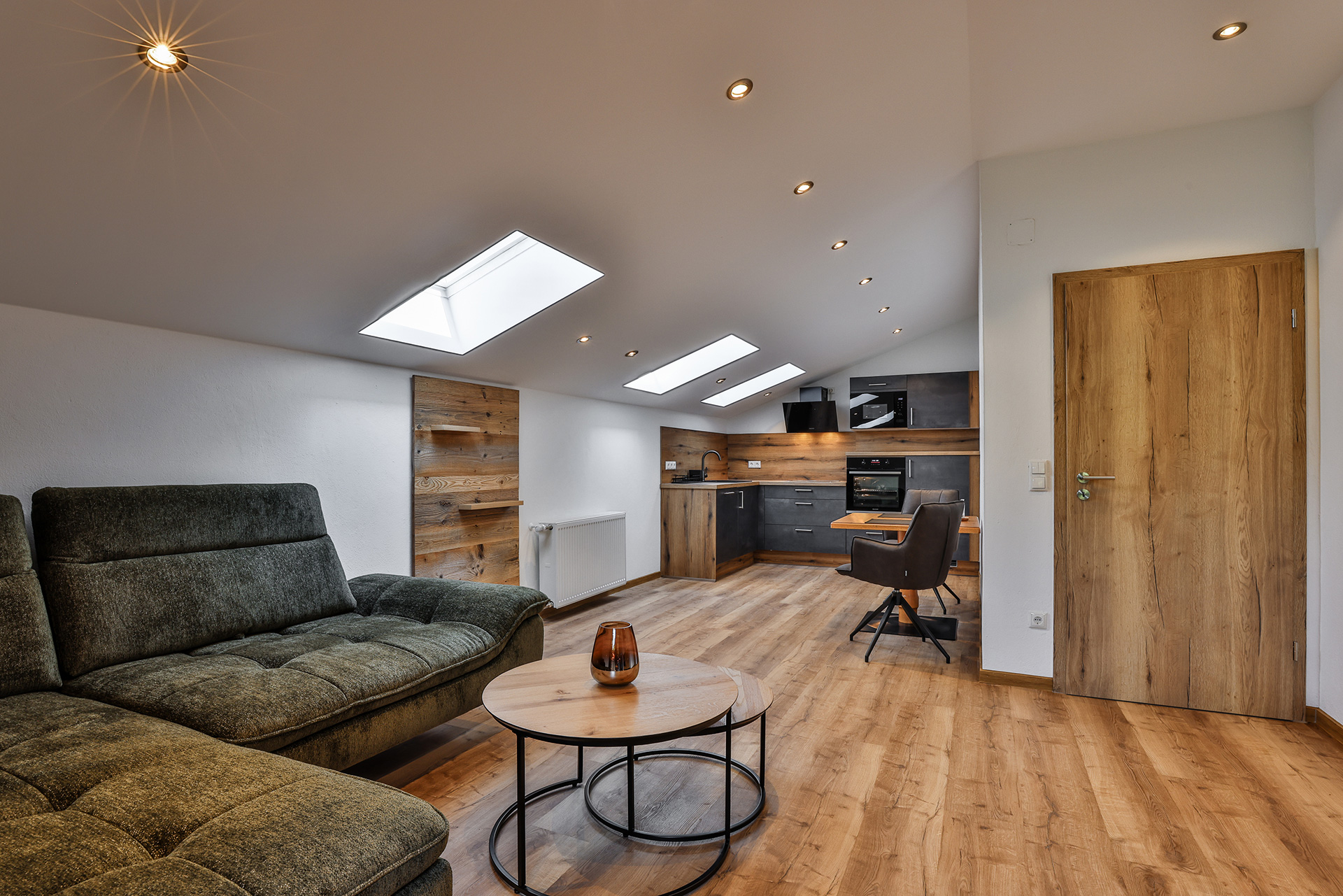Ferienwohnung Jenner Zimmer mit Couch und Küche im alpinen Stile